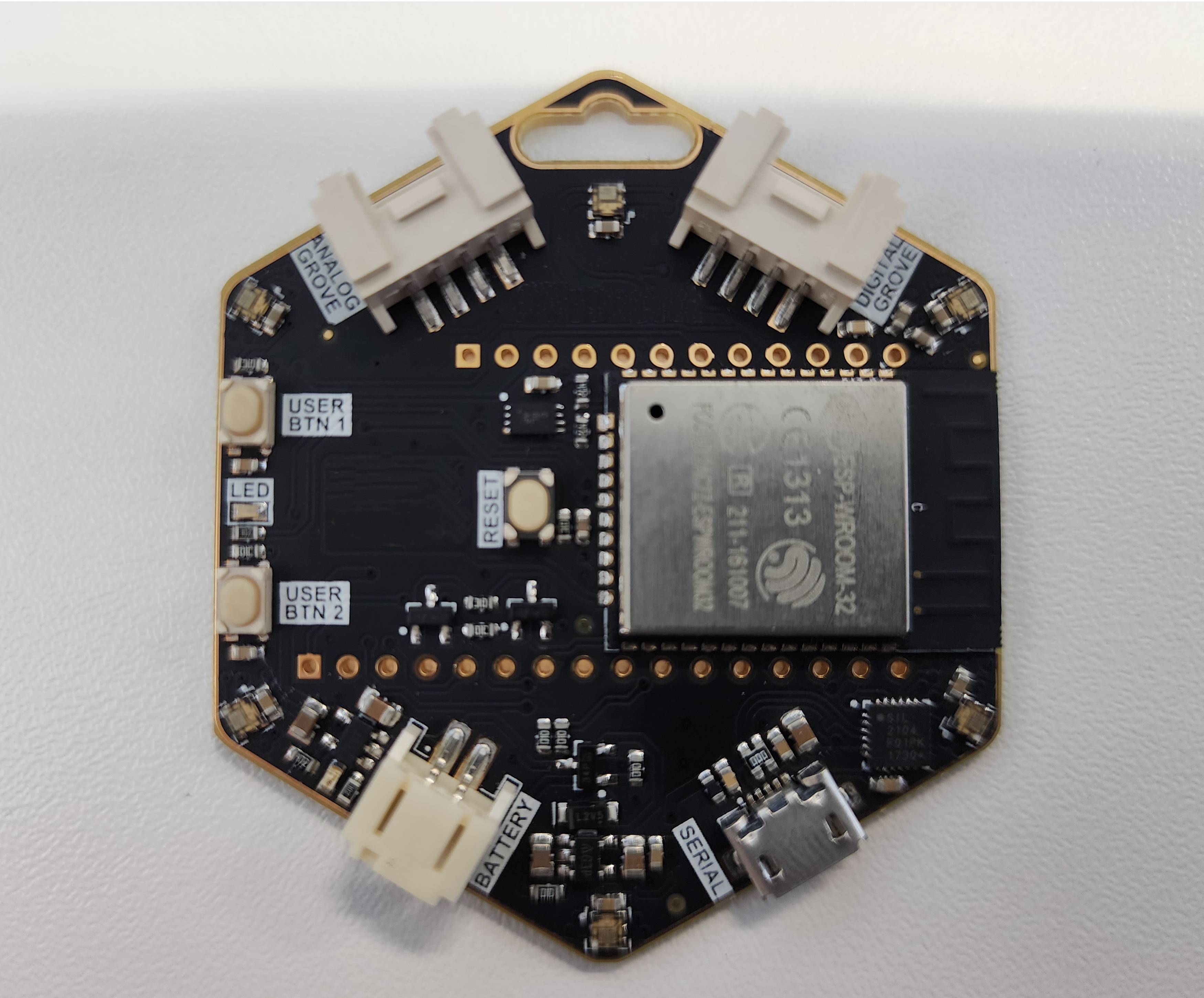 Front of the hexagonal ESP32 conference badge showing the ring of LEDs